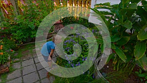 Boy smells flowers in a garden of a Kek Lok Si temple on Penang island, Malaysia