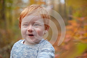 Boy is smiling cute in the autumn forest