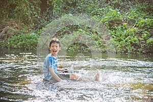 Boy smiling while palying in the river