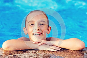 Boy smiling and resting during holidays. Cute boy having fun in the pool