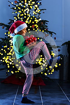 Boy sneak with decoration toys near Christmas tree