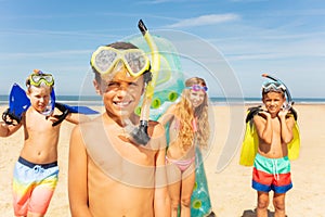 Boy in snorkeling mask stand with group of friends