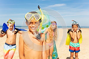 Boy in snorkeling mask stand with group of friends photo