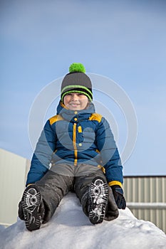 Happy boy in snow play and smile sunny day outdoors