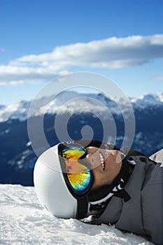 Boy snowboarder lying on mountain.