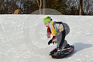 Boy Snowboarding on a Sled in Winter