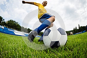 Boy soccer player hits the ball