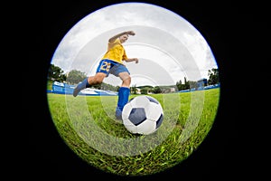 Boy soccer player hits the ball