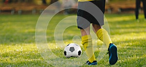 Boy soccer player running after ball. Grass football venue