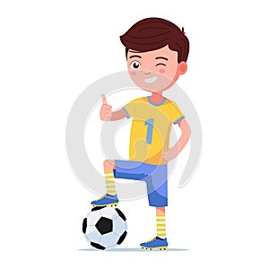 Boy soccer player standing with foot on a ball
