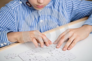 Boy solving a white puzzle