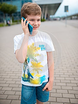 The boy speaks by phone. plays the game