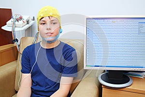 Boy in a special cap during electroencephalography photo