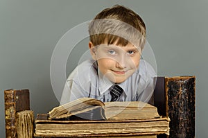 The boy spends time reading old books