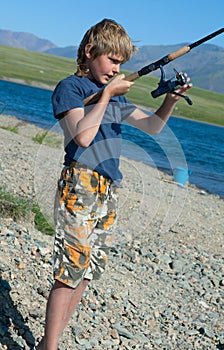 The boy with a spinning catch grayling photo