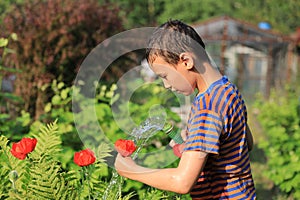 The boy with splash water in very hot summer day outdoors