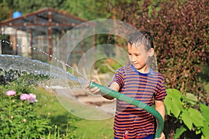 The boy with splash water in very hot summer day outdoors