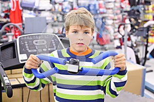 Boy in sports shop tries shoulder expander