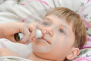 A boy sprinkles medications in his nose for colds and allergies