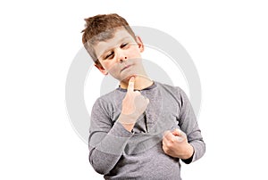 The boy squints, puts a finger to his chin, and thinks about something. Child on a white background