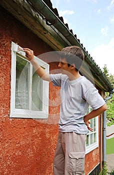 Boy staining window on the outside.