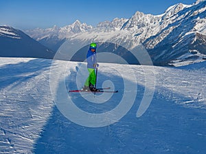 Boy stand on fresh ski track over French mountain summits