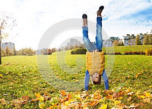 Boy stand on hands on the lawn