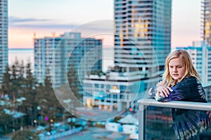 Boy standing on balcony admiring the view from a highrise apartment in Surfers Paradise on the Gold Coast, Queensland Australia