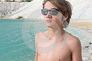 Boy standing on the beach looks into the distance