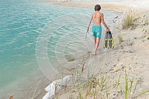 Boy standing on the beach looks into the distance