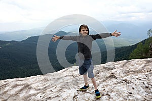 Boy standing on glacier on Lago-Naki plateau in summer