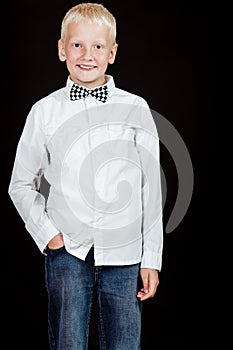 Boy standing with one hand in pocket smiles