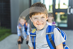 Boy Standing Outside School With Bag