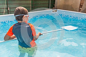 Boy standing in pool with swim noodle, preparing for swimming on a warm sunny day