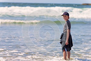 Boy standing in surf on Oregon Coast