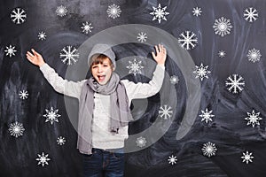 A boy stands on the background of of falling snowflakes