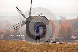 A boy stands on the background of an old mill in the Pirogovo Museum in Kiev, Ukraine