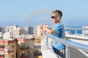 A boy stands on the balcony