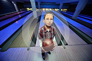 Boy stands with ball for bowling