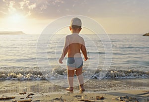 A boy stands on the beach and looks at the sea.Vacation with children