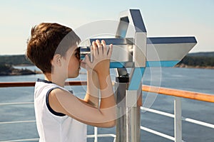 Boy stands and looks through binoculars