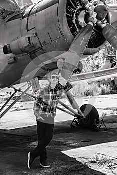 A boy stands near an old plane and thinks about flying when he grows up