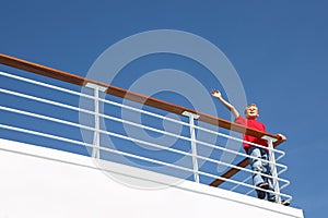 Boy stands at railing on deck of ship