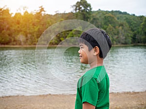 A boy stands by the reservoir in the evening. It shows looking at the goals in life