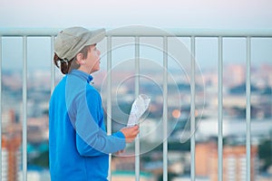 Boy stands on roof of multistory building with photo