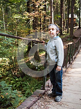 Boy stands on a suspension bridge