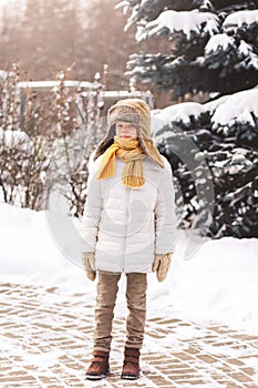 Boy stands in winter in the park on a sunny day