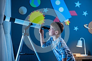 Boy stargazing at night with telescope