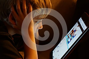 Boy staring at iPad tablet computer photo