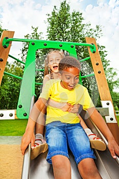 Boy start to slide on chute and girl sit behind